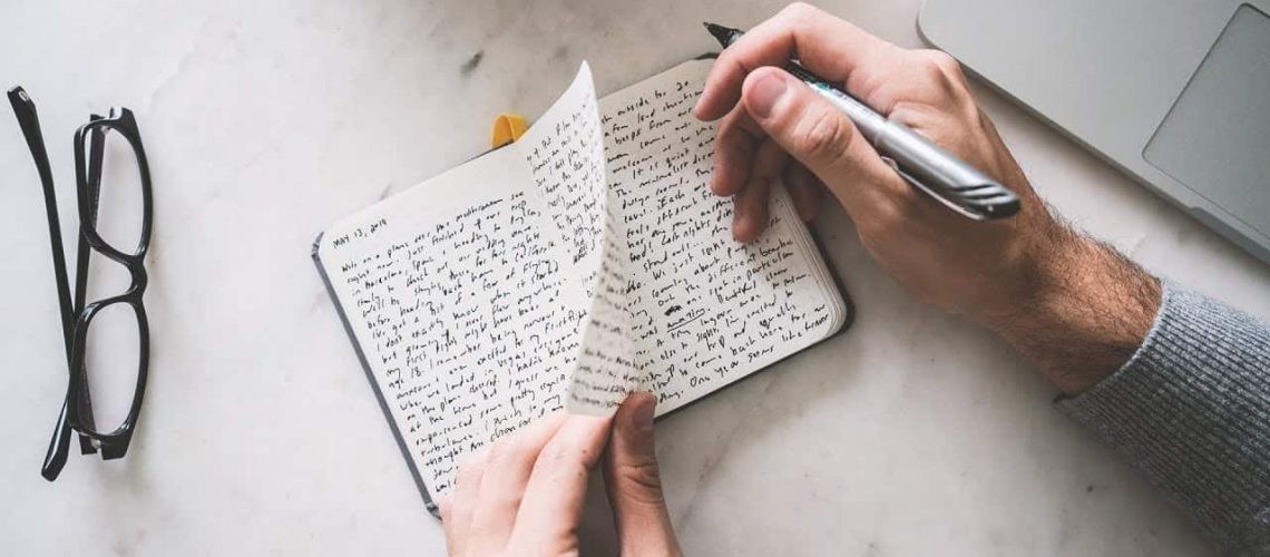 Man writing into a journal